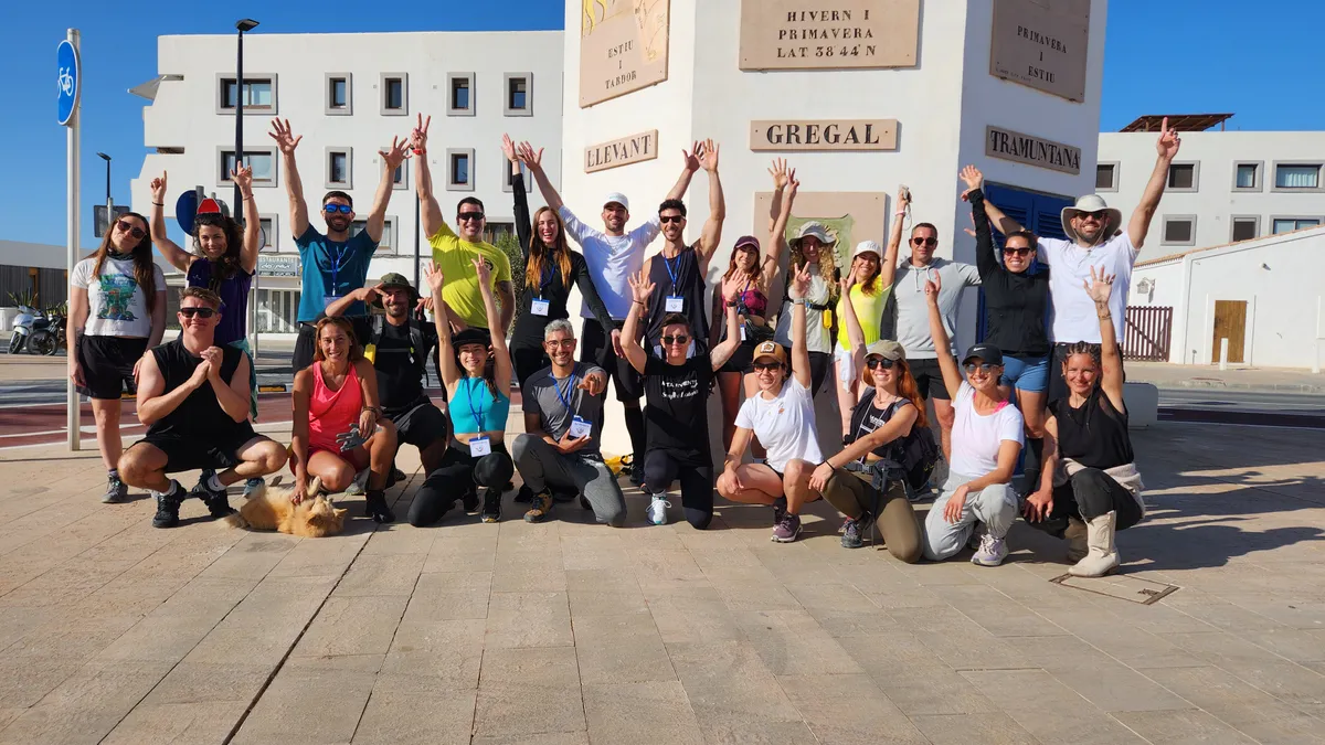 Grupo de voluntarios celebrando junto a la rosa de los vientos del puerto de Formentera